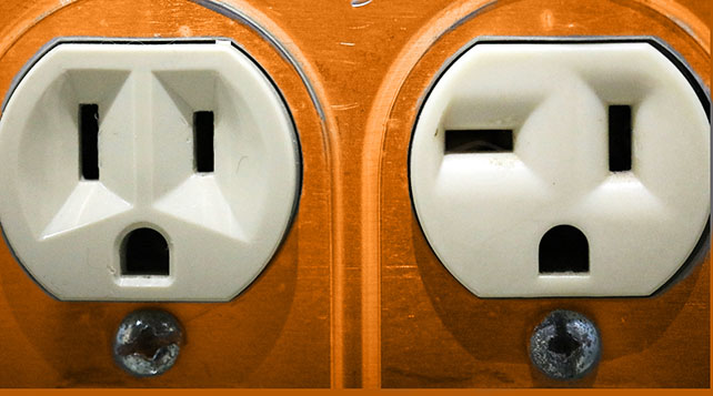 White electrical outlets on an orange background look like surprised faces