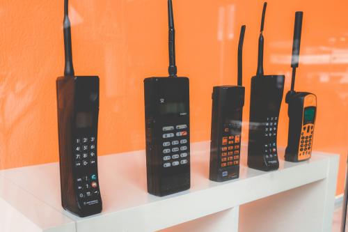Store display of '80s style brick phones with an orange background